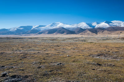 Scenic view of snowcapped mountains against blue sky