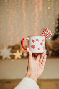 Cropped hand of woman holding coffee cup