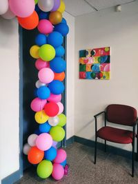 Multi colored balloons on table against wall at home