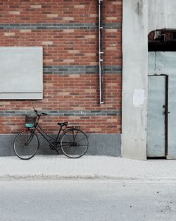 Bicycle on sidewalk against building