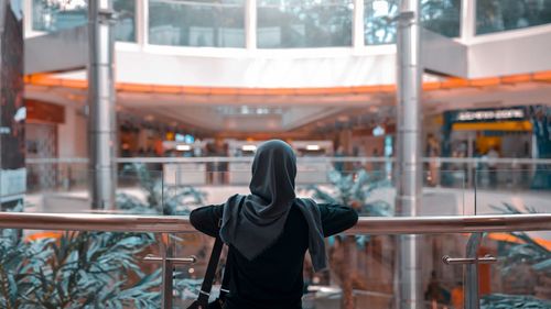Rear view of woman in hijab standing at shopping mall
