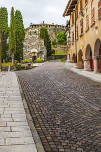 Cobblestone street amidst buildings against sky