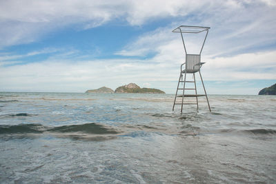 Lifeguard hut on beach against sky