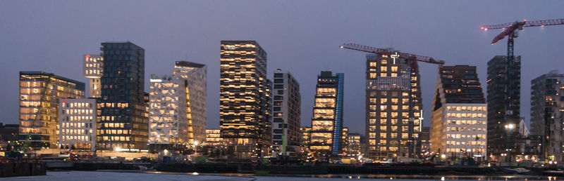 Illuminated cityscape against sky at night