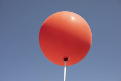 Low angle view of balloons against clear blue sky