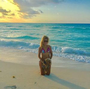 Full length of woman on beach against sky during sunset