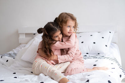 Girl and woman lying on bed at home