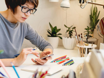 Midsection of woman holding paper with text on table