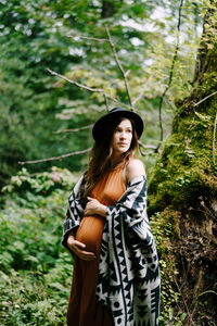 Young woman standing in forest