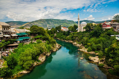 High angle view of townscape by river against sky