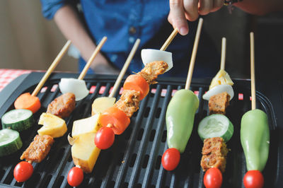 Midsection of man preparing food on barbecue