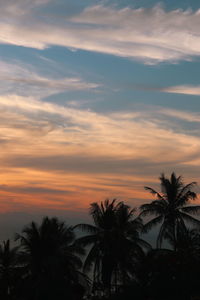 Low angle view of silhouette palm trees against romantic sky