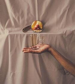 High angle view of woman hand holding glass on bed