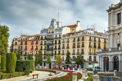 Buildings in city against cloudy sky