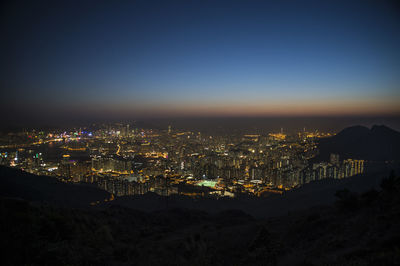 High angle view of illuminated buildings against clear sky at night