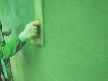 Close-up of hands working against wall