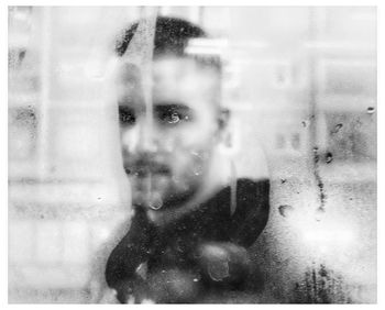 Portrait of man photographing through window