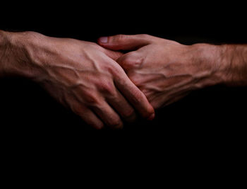 Close-up of human hands against black background