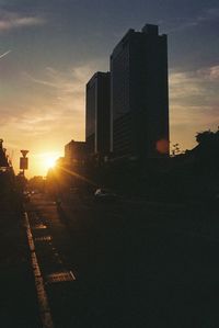 Silhouette buildings against sky during sunset