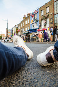 Low section of people walking on road in city