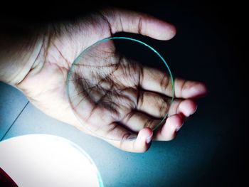 Close-up of human hand holding glass on table