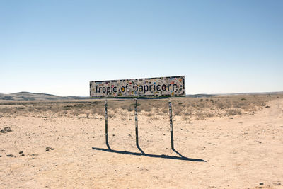 Information sign on field against clear sky