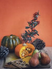 Orange fruits on table against wall