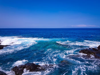 Scenic view of sea against blue sky