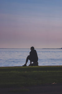 Man standing on beach against sky during sunset