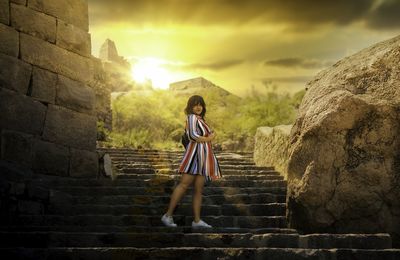 Woman standing on staircase against sky