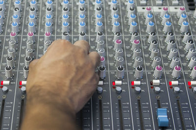 Cropped hand of man mixing music at recording studio