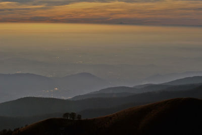 Scenic view of silhouette mountains against sky during sunset