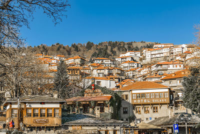 Buildings in town against clear blue sky