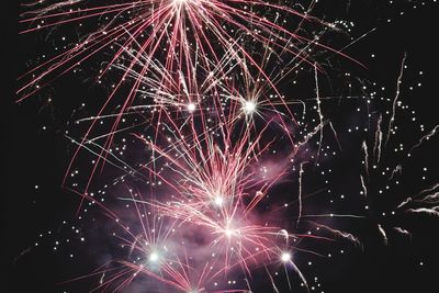 Low angle view of firework display at night