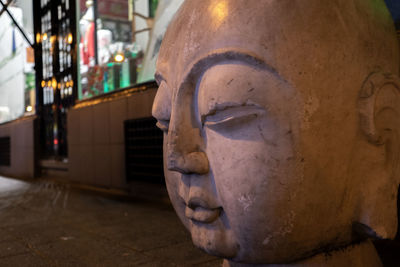 Close-up of buddha statue against building