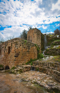 Low angle view of fort against cloudy sky