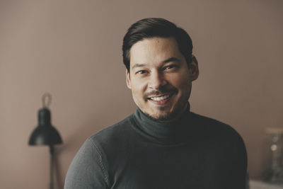 Portrait of smiling businessman wearing turtleneck at office