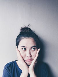 Close-up portrait of young woman against white background