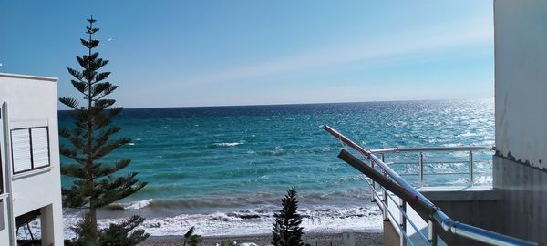 Swimming pool by sea against sky