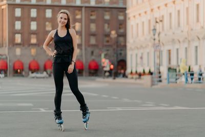 Full length portrait of young woman in city