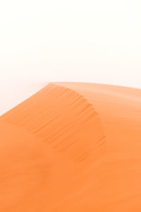 Sand dunes in desert against clear sky