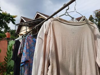 Low angle view of clothes drying on clothesline against sky