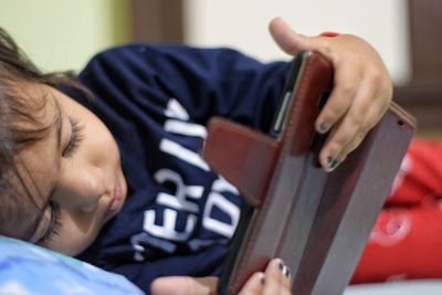 Close-up of boy playing on bed at home