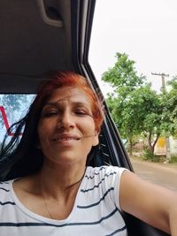 Portrait of smiling woman sitting in car