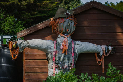 Scarecrow against wooden built structure