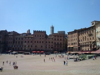 Buildings in city against clear blue sky