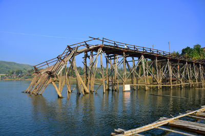 Bridge over river against clear blue sky