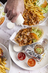 A man pouring yogurt sauce at an indian fast food restaurant