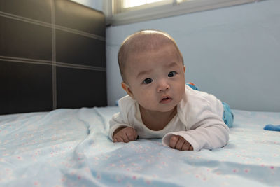 Portrait of cute baby on bed