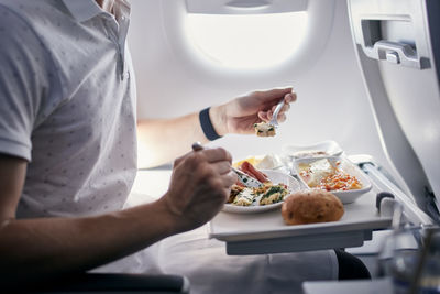 Midsection of man preparing food in plate